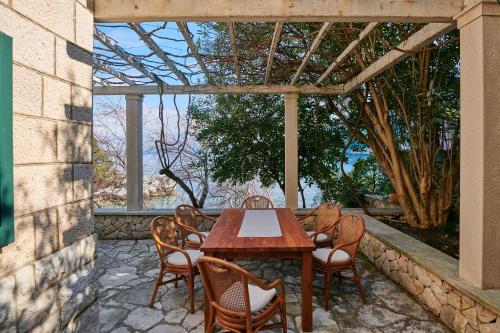 einen Holztisch und Stühle auf einer Terrasse in der Unterkunft Mala kuća Sobra in Sobra