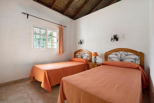 two beds in a room with a window at Casa El Cardon A2 in Buenavista del Norte