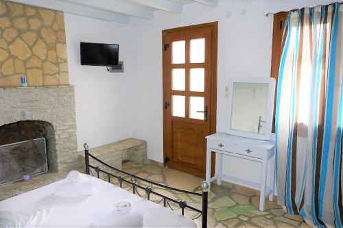 a room with a fireplace and a sink and a mirror at Jasmine apartments in Pythagoreio