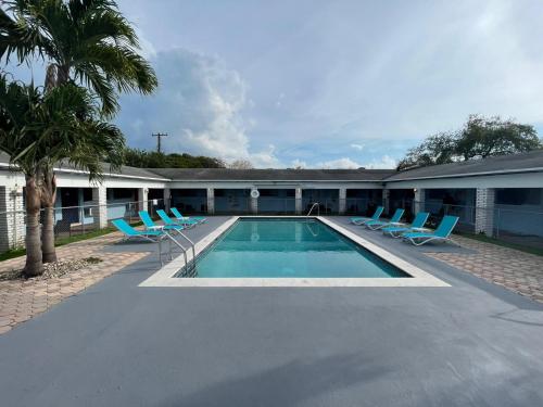 a swimming pool with lounge chairs and a building at Hollywood Gardens Inn & Suites in Hollywood
