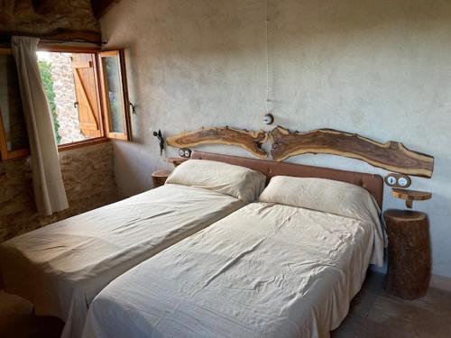 a bedroom with two beds and a wooden headboard at Caseta dels Cirerers in Masdenverge