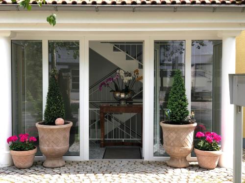 drei Topfpflanzen auf einer Veranda mit Blumen in der Unterkunft Birkenhof-Birke in Bad Wörishofen