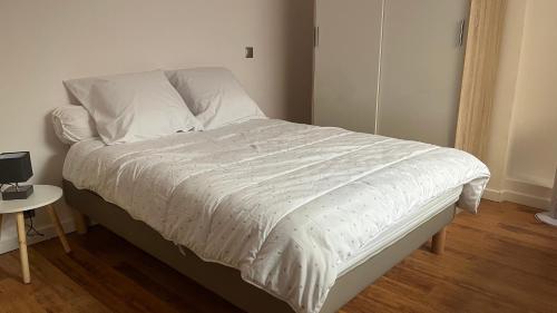 ein Bett mit einer weißen Bettdecke in einem Schlafzimmer in der Unterkunft Marina'home in Ajaccio