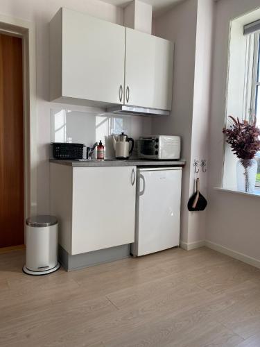 a kitchen with white cabinets and a counter top at Rønhave in Sønderborg