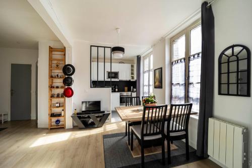 une cuisine et une salle à manger avec une table et des chaises dans l'établissement La Promesse, à Honfleur