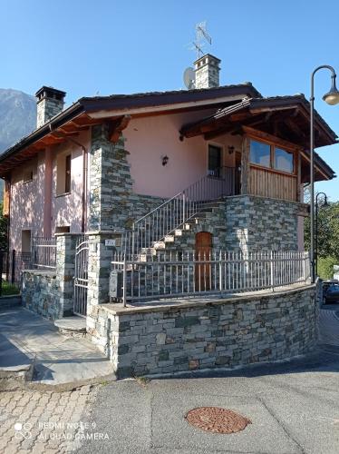 a stone house with a balcony on a street at Torrent du Chateau casa vacanze in Aosta