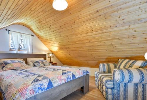 a bedroom with two beds and a wooden ceiling at Holiday House Dorota in Mala Erpenja