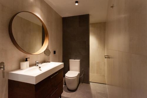 a bathroom with a sink and a toilet and a mirror at Welldone Sierpes Boutique in Seville