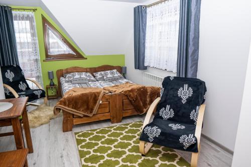a bedroom with a bed and a chair at Noclegi Olszówka in Bukowina Tatrzańska
