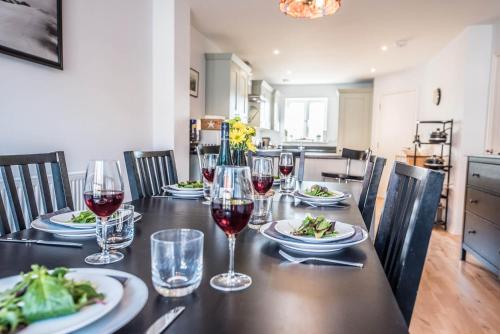 a dining table with wine glasses and plates of food at Rest Ashored, Aldeburgh in Aldeburgh