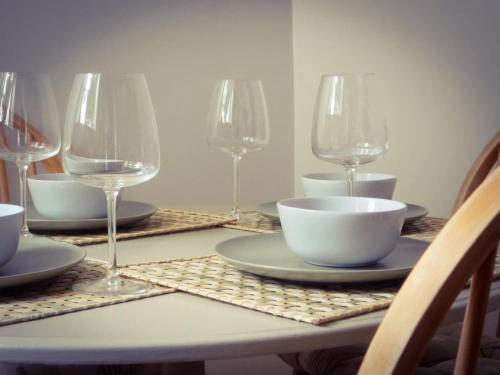 a table with plates and wine glasses on it at Riverdale Cottage in Rhuddlan