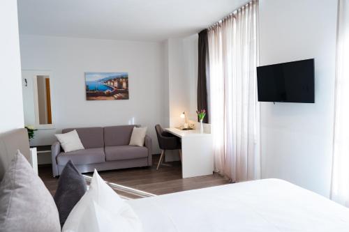 a bedroom with a bed and a living room with a couch at Hotel La Fleur in Überlingen