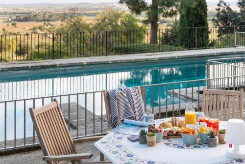 a table with food on it next to a swimming pool at Finca Son Cladera in Sa Pobla