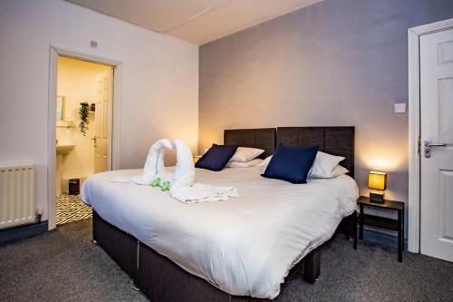 - une chambre dotée d'un grand lit avec des draps blancs et des oreillers bleus dans l'établissement Browney Place, à Durham