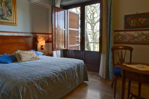a bedroom with a bed and a table and a window at Miralago in Albano Laziale
