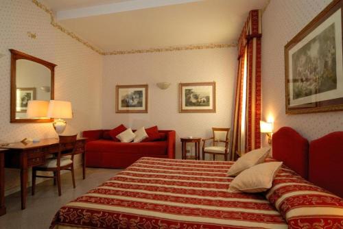 a hotel room with a bed and a red couch at Miralago in Albano Laziale