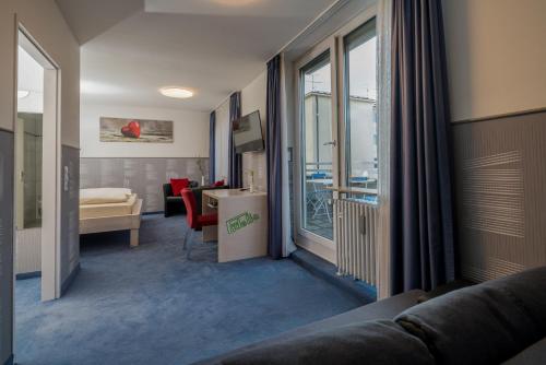 a living room with a couch and a room with a window at Hotel Fidelio in Munich