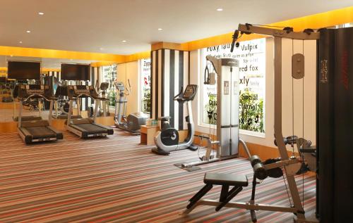 a gym with a bunch of treadmills and machines at Red Fox Hotel, Delhi Airport in New Delhi