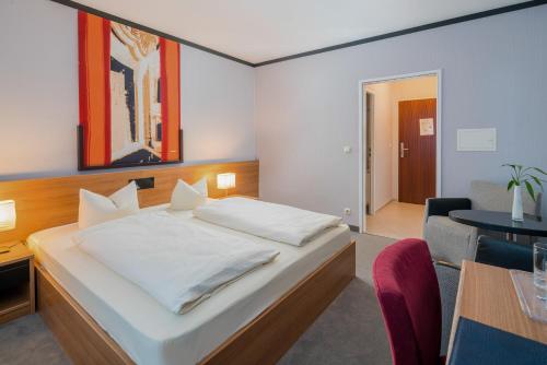a bedroom with a bed and a dining room at Hotel Fidelio in Munich