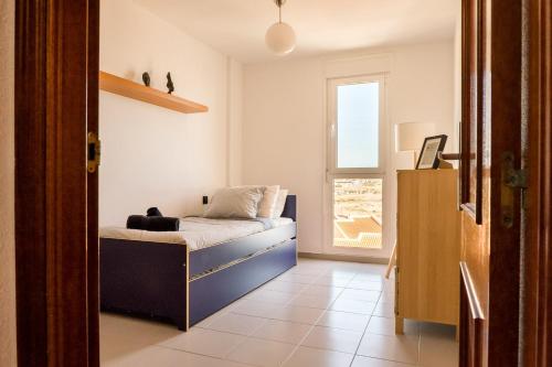 een kleine slaapkamer met een bed en een raam bij El Cabezo Médano 1ª Linea in El Médano