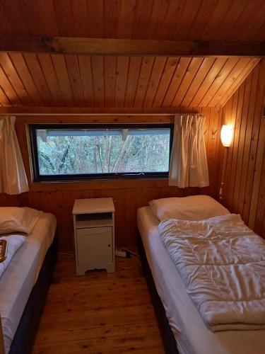 a small room with two beds and a window at fraai chalet Barvaux in Durbuy