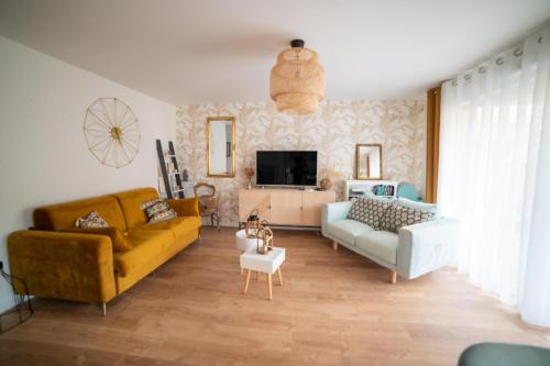 un salon avec deux canapés et une télévision dans l'établissement GOLDEN, à Saint-Malo