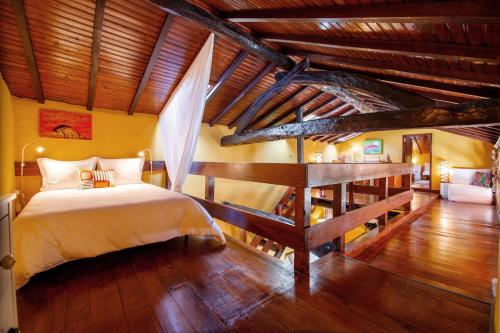 1 dormitorio con cama y techo de madera en Casa do Piano, en Longos