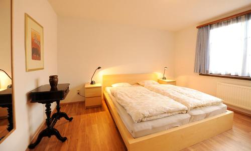 a bedroom with a bed and a desk and a window at Ferienhaus Michi in St. Andrä am Zicksee