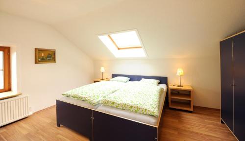 a bedroom with a large bed and a skylight at Ferienhaus Michi in St. Andrä am Zicksee