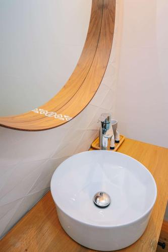 a bathroom with a white sink on a wooden floor at Conacul Olarilor in Baia de Fier