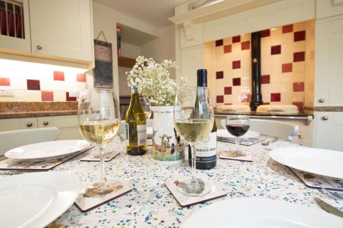 een tafel met wijnglazen en flessen wijn bij Gargoyle Cottage in St. Agnes 