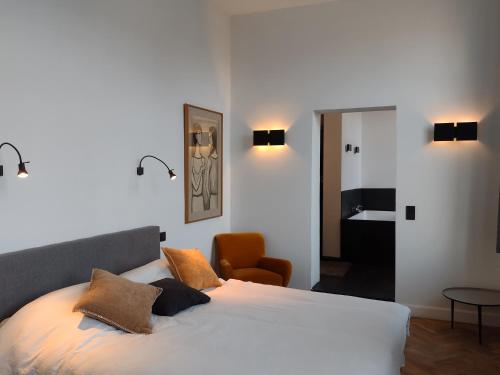 a bedroom with a bed with pillows and a chair at Peter House in Nivelles