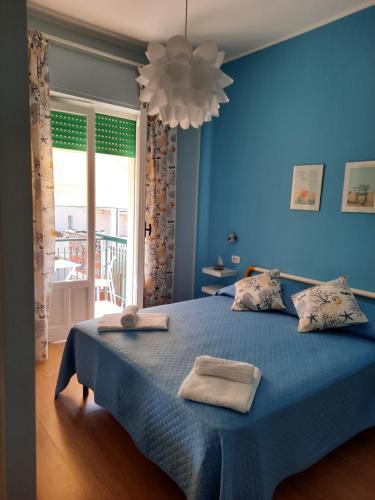 a blue bedroom with a bed with two towels on it at Affittacamere Mirella in Pineto