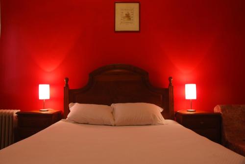 a bedroom with red walls and a bed with two lamps at Costa Verde in Vila Nova de Cerveira