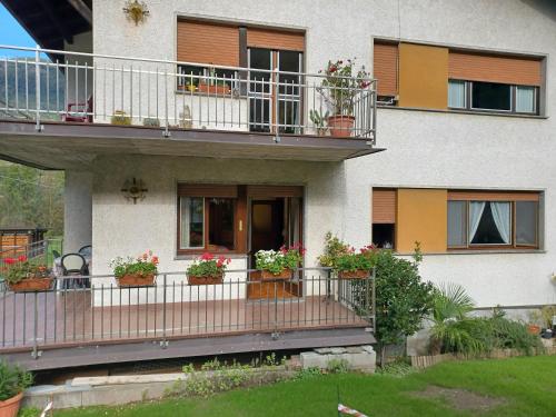 a building with potted plants on its balcony at B & B SENTIERO VALTELLINA in Castello dellʼAcqua