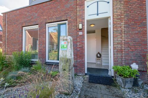 a brick house with a parking meter in front of it at Texels Verzetje in Den Burg