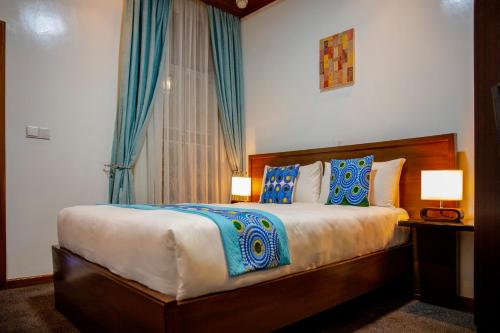 ein Schlafzimmer mit einem großen Bett mit blauen und weißen Kissen in der Unterkunft Villa Asimba in Kigali