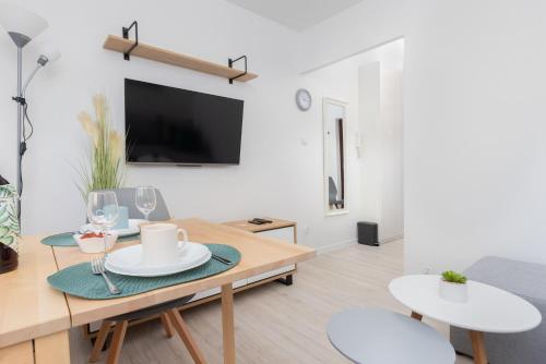 a living room with a table and chairs and a tv at Apartament Przystań Gdynia by Renters in Gdynia