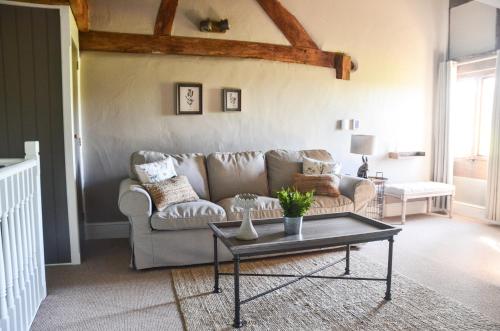 a living room with a couch and a coffee table at The Threshing Barn at Penrhos Court in Kington