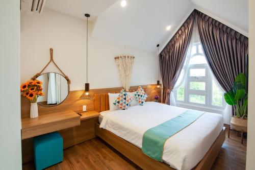 a bedroom with a large bed and a mirror at The View Hotel in Cam Lâm
