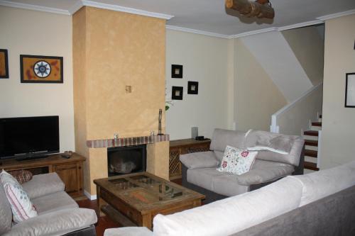 a living room with two couches and a fireplace at La Cerca de Torrecaballeros, a 10 min de Segovia in Torrecaballeros