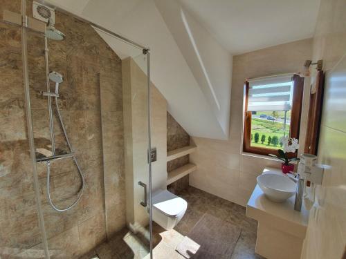 a bathroom with a shower and a sink at Mrowca Noclegi Pokoje Gościnne in Gronków