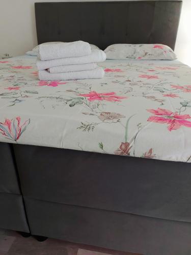 a bed with a floral bedspread with towels on it at Apartment Ante and Dijana in Starigrad-Paklenica