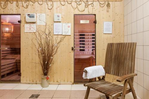 a wooden room with a chair and a window at BURSZTYN - BERNSTEIN APARTMENTS in Dąbki