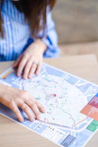 a woman is looking at a map on a table at Hotel du Théâtre in Bruges
