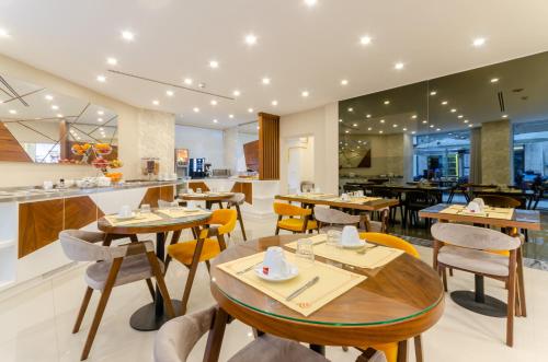 un restaurant avec des tables et des chaises en bois et un comptoir dans l'établissement Hotel Duas Nações, à Lisbonne