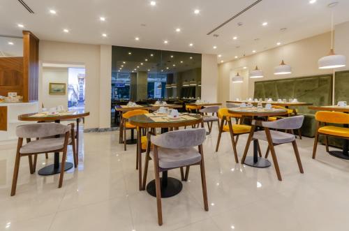 a restaurant with wooden tables and yellow chairs at Hotel Duas Nações in Lisbon