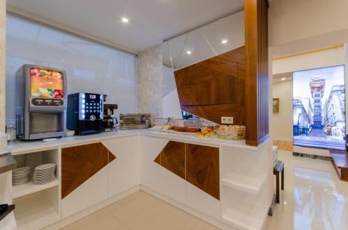 a kitchen with a counter with a coffee maker and a microwave at Hotel Duas Nações in Lisbon