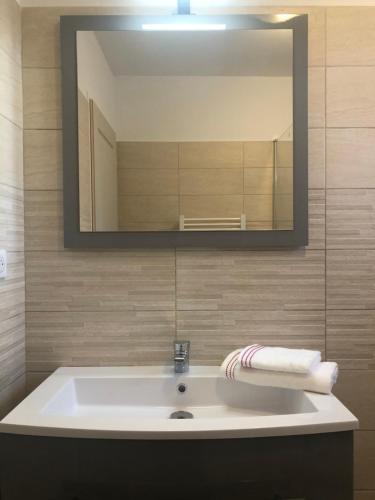 ein Bad mit einem Waschbecken und einem Spiegel in der Unterkunft U SOLE in Ajaccio