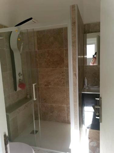 une salle de bain avec une douche avec une porte vitrée dans l'établissement Appartement chaleureux à Cavalaire-sur-Mer 40 m² avec terrasse, à Cavalaire-sur-Mer